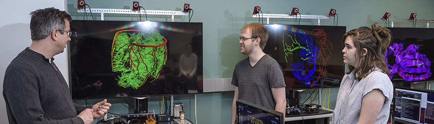 photo of a professor and students in the immersive visualization and animation theater