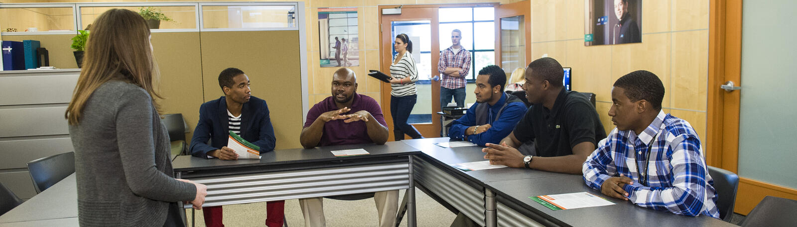 photo of an advisor and students in a conference room