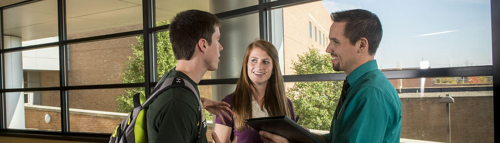 photo of two students talking to an instructor in the joshi center