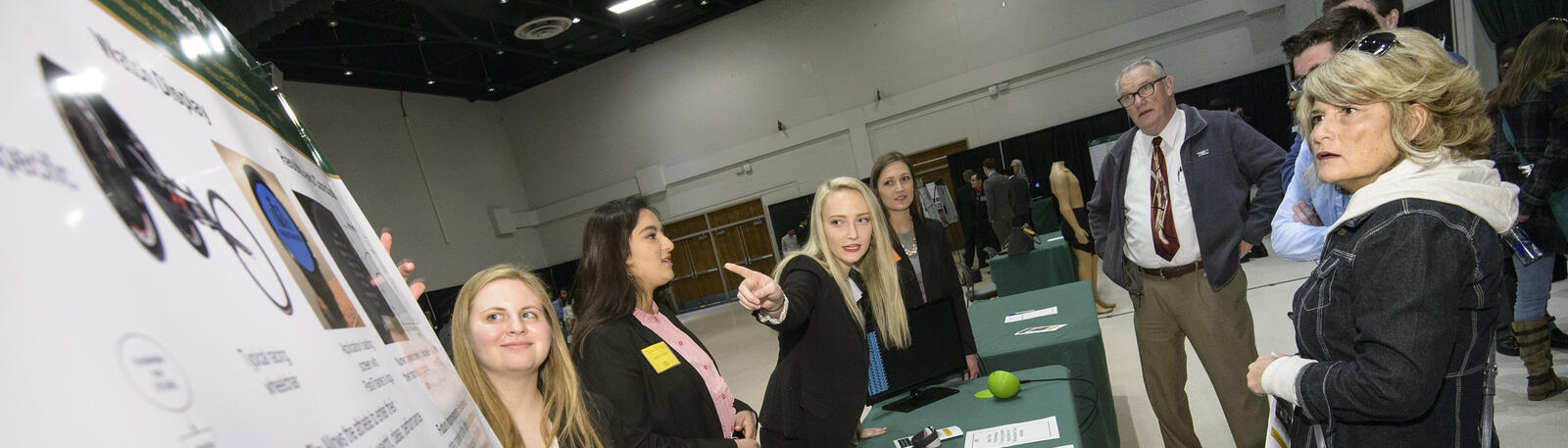 photo of students and attendees at a poster session